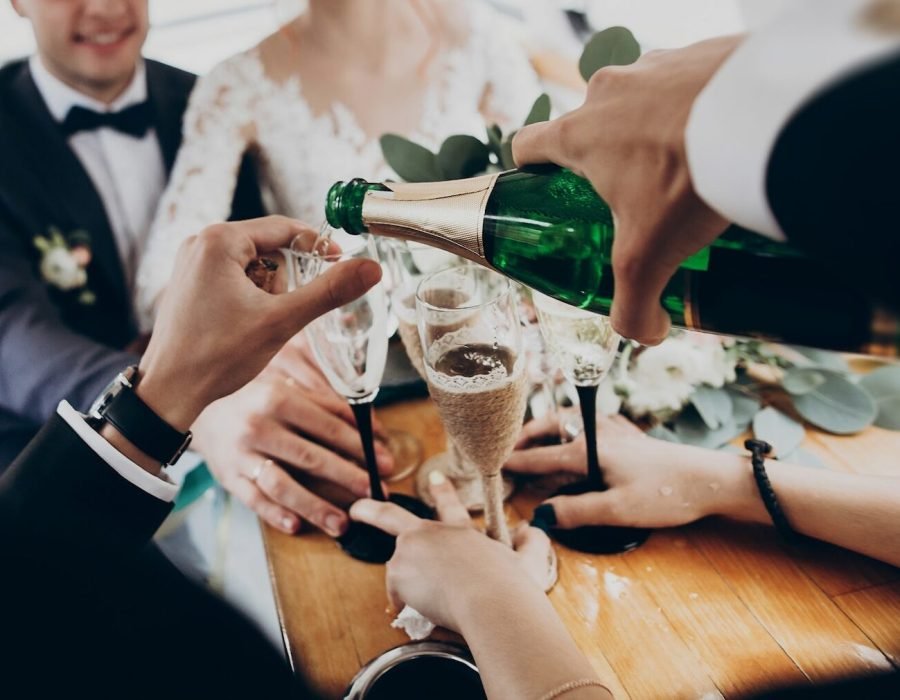 stylish-happy-bride-and-groom-toasting-with-glasses-of-champagne-and-having-fun.jpg